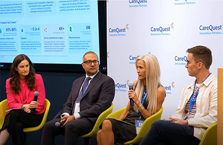 Panel of four speakers seated on stage in bright chairs, two women with microphones and two men, backdrop shows CareQuest Innovation Partners branding.